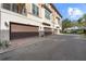 Exterior view of townhome style condos with multiple garages and neutral colored stucco at 417 Pavia Loop, Lake Mary, FL 32746