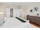 Serene main bedroom with white bedding, a dresser, closet and soothing decor at 417 Pavia Loop, Lake Mary, FL 32746