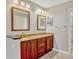 Bathroom features double sinks with framed mirrors, cabinets and granite countertops at 4818 Breezy Palms Ct, Windermere, FL 34786