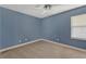 Neutral carpeted bedroom featuring a ceiling fan and a window with blinds at 4818 Breezy Palms Ct, Windermere, FL 34786