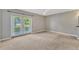 Spacious bedroom with neutral carpet, ceiling fan, and sliding glass doors to the yard at 4818 Breezy Palms Ct, Windermere, FL 34786