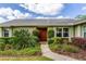 Charming home featuring a well-manicured lawn and a vibrant front door with verdant landscaping at 4818 Breezy Palms Ct, Windermere, FL 34786