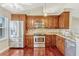 Updated kitchen with wooden cabinets, stainless steel appliances, granite countertops, and hardwood floors at 4818 Breezy Palms Ct, Windermere, FL 34786