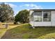 Home's exterior showcasing a screened porch and grassy yard at 50989 Highway 27 # 25, Davenport, FL 33897