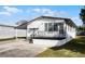 Front view of a white manufactured home with a carport at 50989 Highway 27 # 25, Davenport, FL 33897