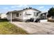 White manufactured home with a carport and small yard at 50989 Highway 27 # 25, Davenport, FL 33897