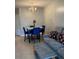 Dining area with marble-top table and blue chairs, adjacent to living room at 538 Bexley Dr, Davenport, FL 33897