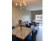 Dining area with marble-top table, blue chairs, and a chandelier at 538 Bexley Dr, Davenport, FL 33897