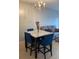 Dining area with marble-top table and four blue chairs at 538 Bexley Dr, Davenport, FL 33897