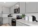 Modern kitchen with gray cabinets, quartz countertops, and breakfast bar at 6505 Breeze Filled Ln, Winter Garden, FL 34787