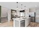 Modern kitchen with island, stainless steel appliances, and gray cabinets at 6505 Breeze Filled Ln, Winter Garden, FL 34787