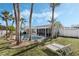 Landscaped backyard with a pool, palm trees and lounge chairs at 798 Saint Johns River Dr, Sanford, FL 32773