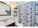 Charming bathroom with blue floral shower curtain and wood vanity at 798 Saint Johns River Dr, Sanford, FL 32773