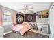 Cozy bedroom featuring a pink bed and eclectic wall decor at 798 Saint Johns River Dr, Sanford, FL 32773