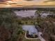 Sunset aerial view of lakefront home and surrounding landscape at 9229 Lake Hickory Nut Dr, Winter Garden, FL 34787