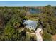 House on a lake with lush vegetation, a long driveway, and a metal roof at 9229 Lake Hickory Nut Dr, Winter Garden, FL 34787