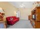 Living room featuring red couch and wooden entertainment center at 9229 Lake Hickory Nut Dr, Winter Garden, FL 34787