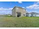 Spacious backyard with lush green grass, patio, and modern two-story house at 958 Anna Pl, Davenport, FL 33837