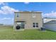 Backyard with lush green grass, patio, AC Unit, and modern two-story house with solar panels at 958 Anna Pl, Davenport, FL 33837