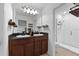 Bathroom boasts double sink vanity with dark cabinets and a tiled glass-enclosed shower at 958 Anna Pl, Davenport, FL 33837