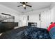 Bedroom showcases media center with large TV and the bed with a black plush coverlet at 958 Anna Pl, Davenport, FL 33837