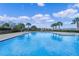 Large community pool with lounge chairs and shade umbrellas for relaxing at 958 Anna Pl, Davenport, FL 33837