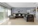 Bright living room featuring tile flooring, a large comfortable gray sectional sofa, and natural light from sliding glass doors at 958 Anna Pl, Davenport, FL 33837