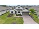 Beautiful two-story home with gray shingle roof, landscaping, and brick driveway at 960 Ladera Ranch Rd, Poinciana, FL 34759