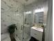 Elegant bathroom with marble tile, frameless glass shower, and modern vanity at 3020 Cardillino Way, Kissimmee, FL 34741