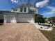 Two-story house with gray exterior, paver driveway, and landscaping at 3020 Cardillino Way, Kissimmee, FL 34741