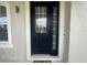 Modern dark-blue front door with sidelights and decorative doormat at 3020 Cardillino Way, Kissimmee, FL 34741