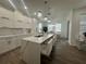 Modern white kitchen with large island, quartz countertops, and stainless steel appliances at 3020 Cardillino Way, Kissimmee, FL 34741