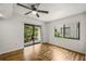 Well-lit bedroom with hardwood floors, ceiling fan and glass sliding door to the outside at 1000 Winderley Pl # 143, Maitland, FL 32751