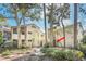 Charming exterior of a two-story residence surrounded by mature trees, a tile roof and walkway at 1000 Winderley Pl # 143, Maitland, FL 32751