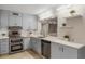 Bright kitchen showcasing stainless steel appliances, light countertops, and blue cabinets at 1000 Winderley Pl # 143, Maitland, FL 32751
