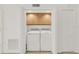 Convenient laundry closet includes washer, dryer, and overhead storage cabinets at 1000 Winderley Pl # 143, Maitland, FL 32751