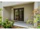 Enclosed patio featuring a sliding glass door surrounded by greenery and flowers at 1000 Winderley Pl # 143, Maitland, FL 32751