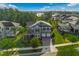 Aerial view of a two-story house with manicured lawn, mature trees, and a lake view at 10219 Atwater Bay Dr, Winter Garden, FL 34787