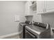 Well-lit laundry room with front load washer and dryer and white cabinets at 10219 Atwater Bay Dr, Winter Garden, FL 34787