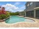 Backyard pool and patio area with colorful shrubs and green lawn at 10219 Atwater Bay Dr, Winter Garden, FL 34787
