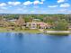 Aerial shot showcases a large estate on the water with a pool, lush landscaping, and mature trees at 11900 Lake Butler Blvd, Windermere, FL 34786
