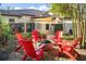 Inviting backyard featuring a fire pit with red Adirondack chairs, perfect for outdoor gatherings at 11900 Lake Butler Blvd, Windermere, FL 34786