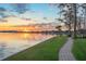 Expansive waterfront property with lush green lawn and a paved path along the serene lake at 11900 Lake Butler Blvd, Windermere, FL 34786