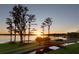 Scenic backyard with a wooden bridge over a waterway leading to a serene lake at sunset at 11900 Lake Butler Blvd, Windermere, FL 34786