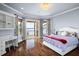 Bright bedroom with hardwood floors, built-in shelving, and a balcony offering picturesque lake views at 11900 Lake Butler Blvd, Windermere, FL 34786