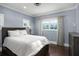 Comfortable bedroom with a large window view, hardwood floors, and cool toned walls at 11900 Lake Butler Blvd, Windermere, FL 34786