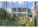 A luxurious two story home framed by trees and greenery featuring a large screened-in balcony at 11900 Lake Butler Blvd, Windermere, FL 34786