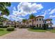 Stunning exterior view of a Mediterranean-style home with a brick driveway, lush landscaping, and palm trees at 11900 Lake Butler Blvd, Windermere, FL 34786