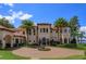 Elegant home features a circular driveway with a fountain, lush landscaping, and Mediterranean architecture at 11900 Lake Butler Blvd, Windermere, FL 34786