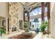 Grand living room with soaring ceilings, a stone fireplace, and expansive windows overlooking the water at 11900 Lake Butler Blvd, Windermere, FL 34786
